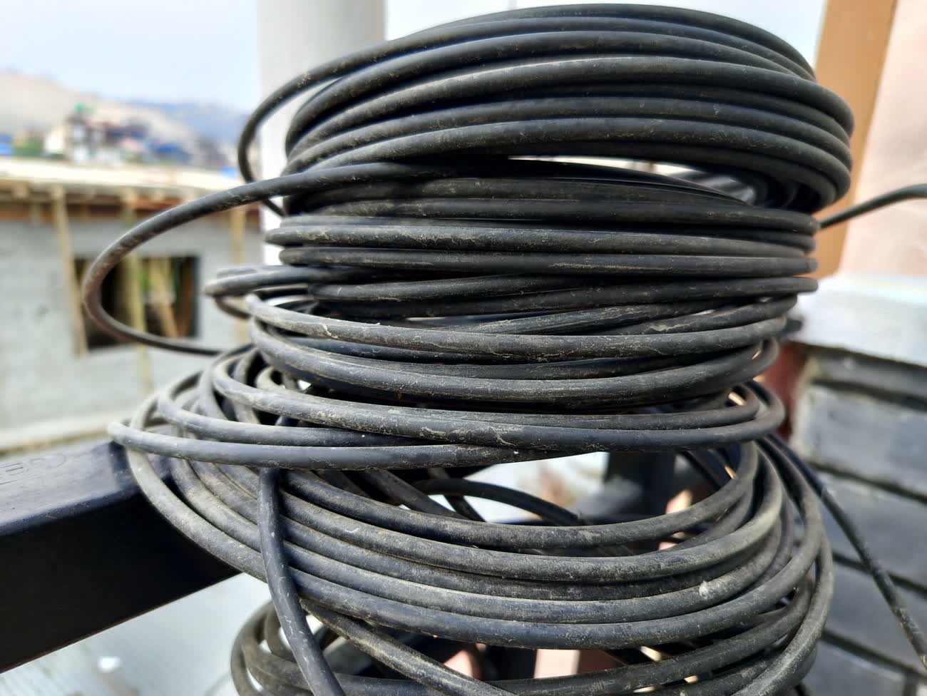 A tangled stack of coiled black cable